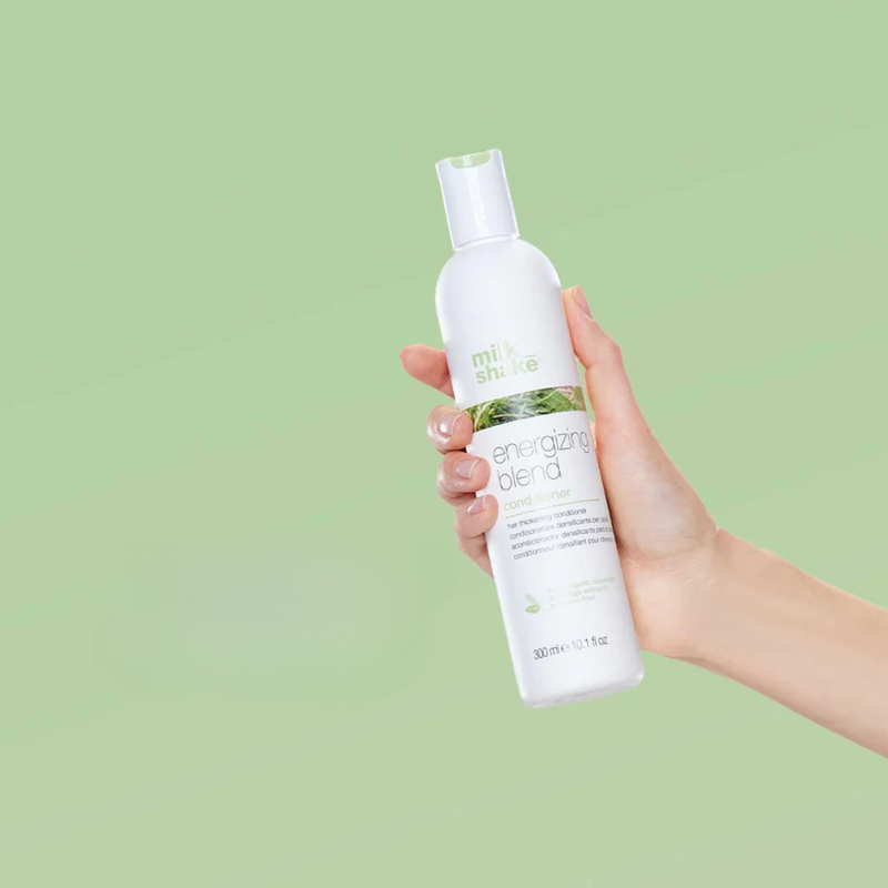 Energizing Blend Conditioner holdes i hånden